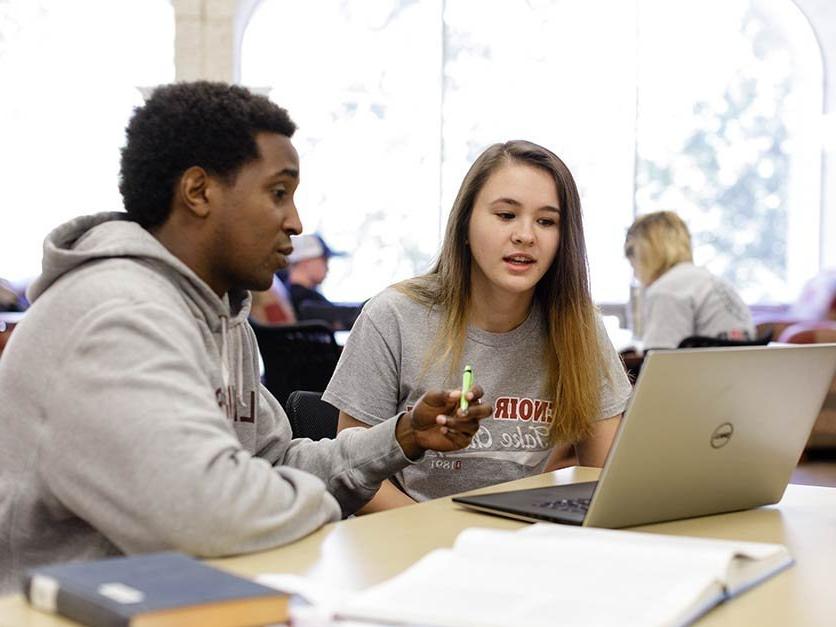 Student assists another student with class assignment 